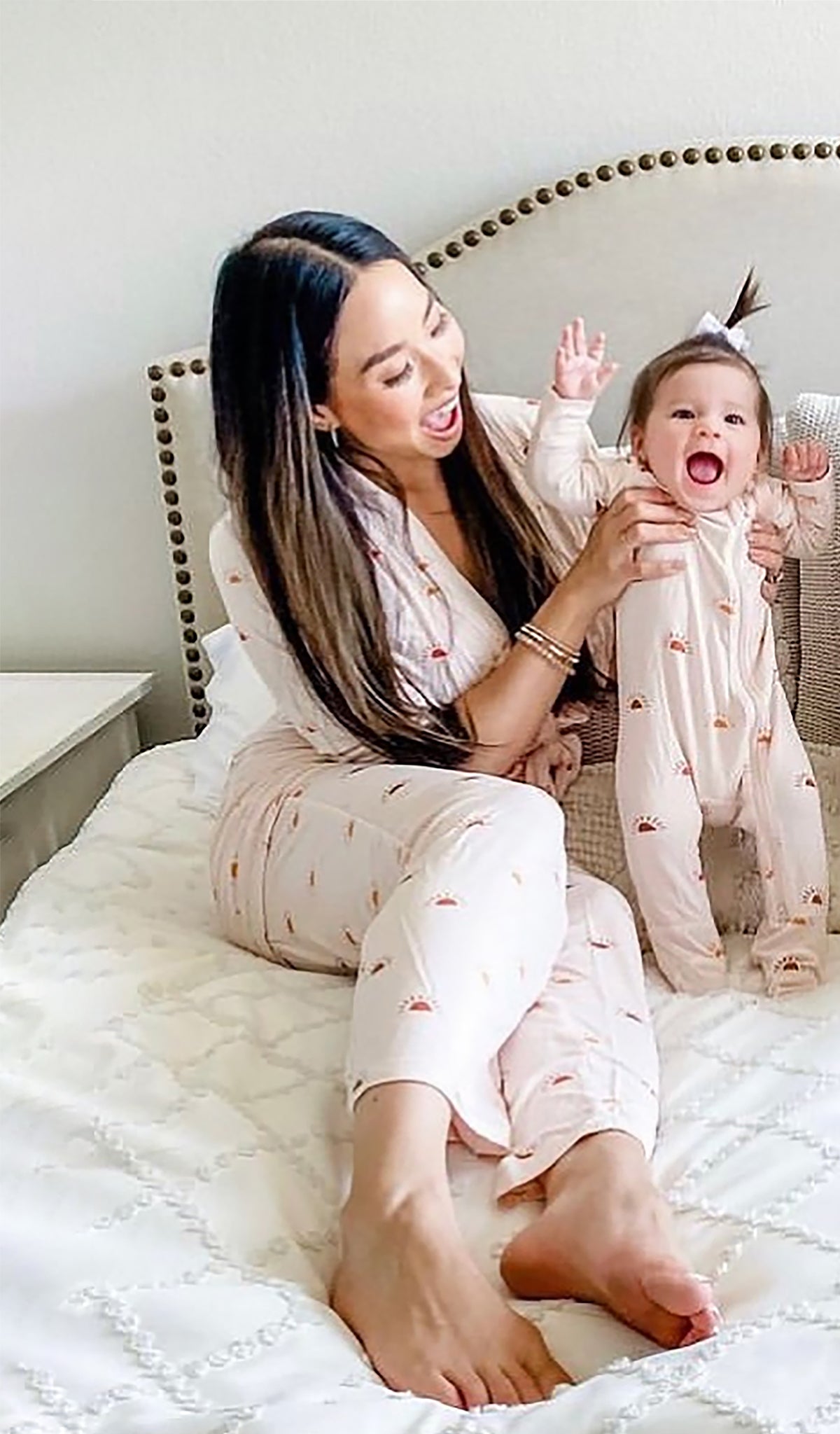 Footie 2-Piece - Sunrise worn by baby girl being held by her mom who is wearing matching pajamas.