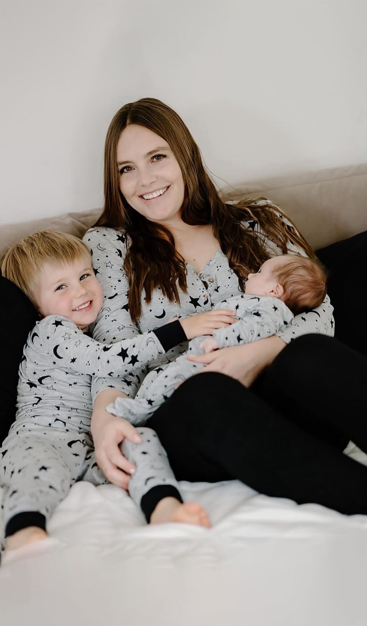 Twinkle Night Footie worn by baby being hugged by his mom and big brother.