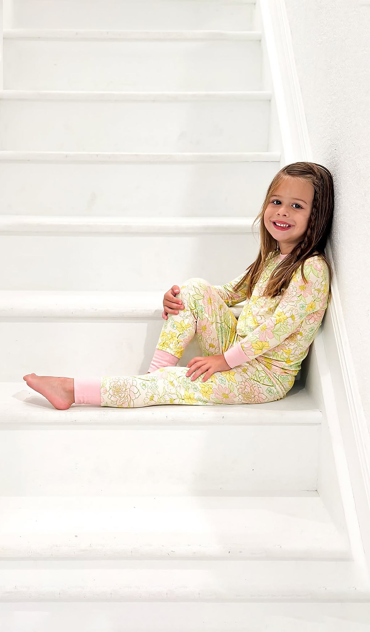 Emerson Begonia floral 2 piece PJ worn by little girl sitting on stairs.