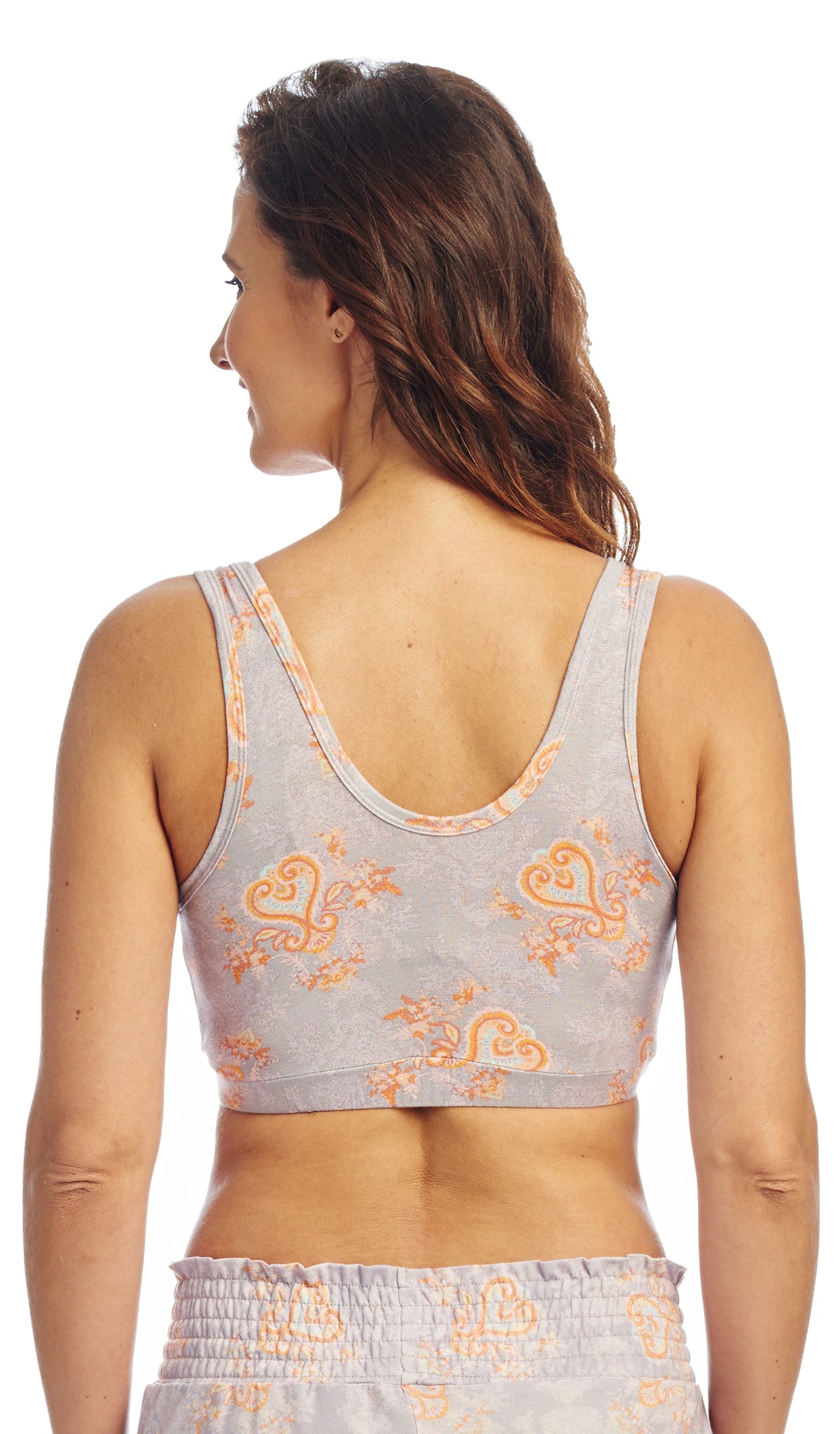 Backl shot of woman wearing a light gray sleep bra with orange floral patterns on a white background