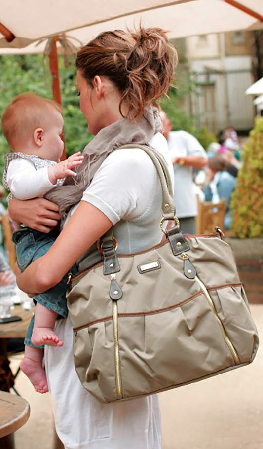 Storksak Olivia Diaper Bag carried by woman holding baby.