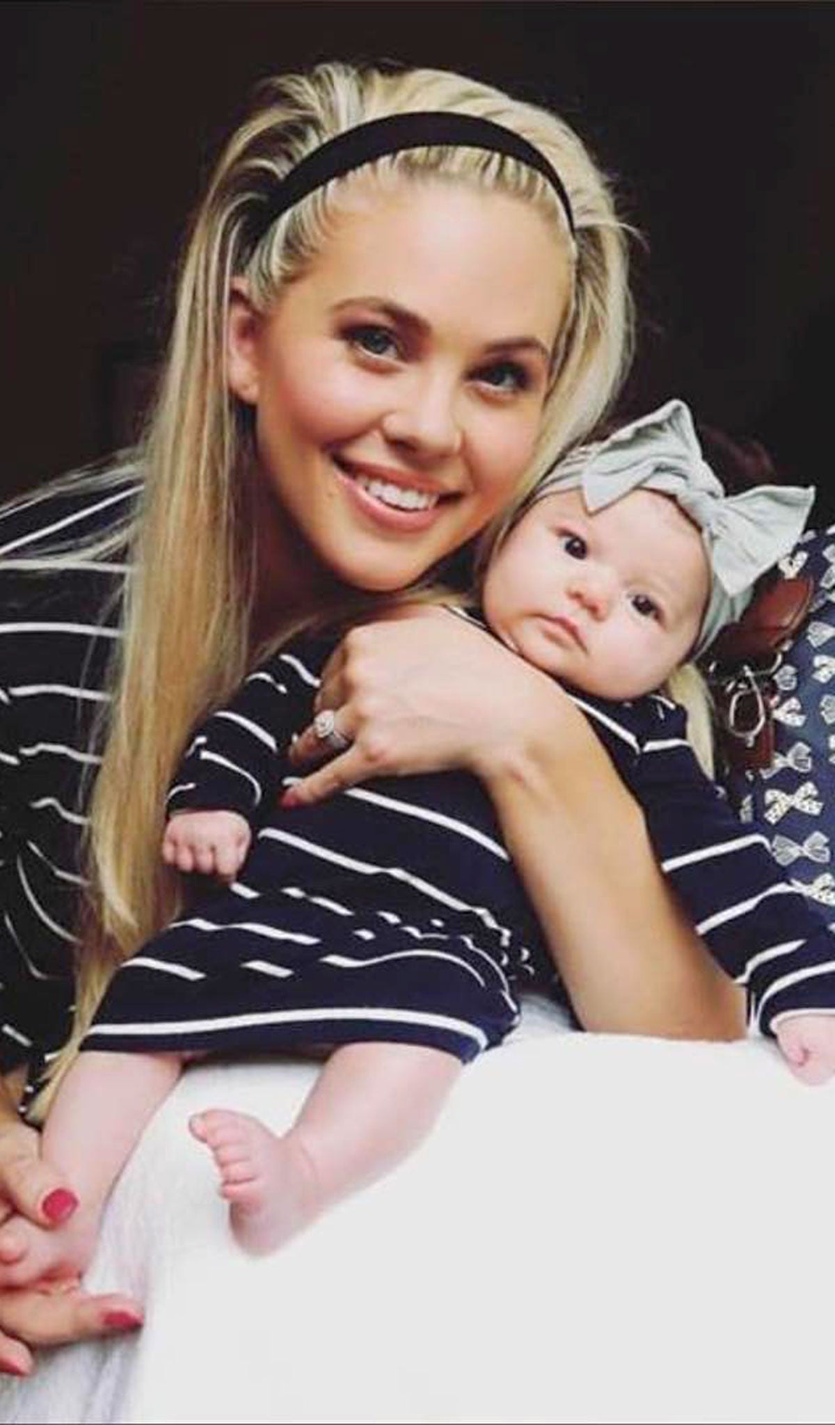 Baby's Welcome Home 3 Piece Set - Navy. Baby wearing baby gown while being hugged by her mom.
