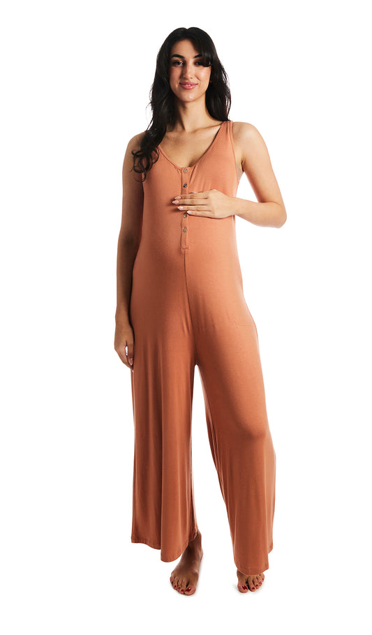 Sandstone Luana romper. Pregnant woman with one hand on belly, wearing sleeveless wide-leg romper with scoop-neckline with button-front placket.