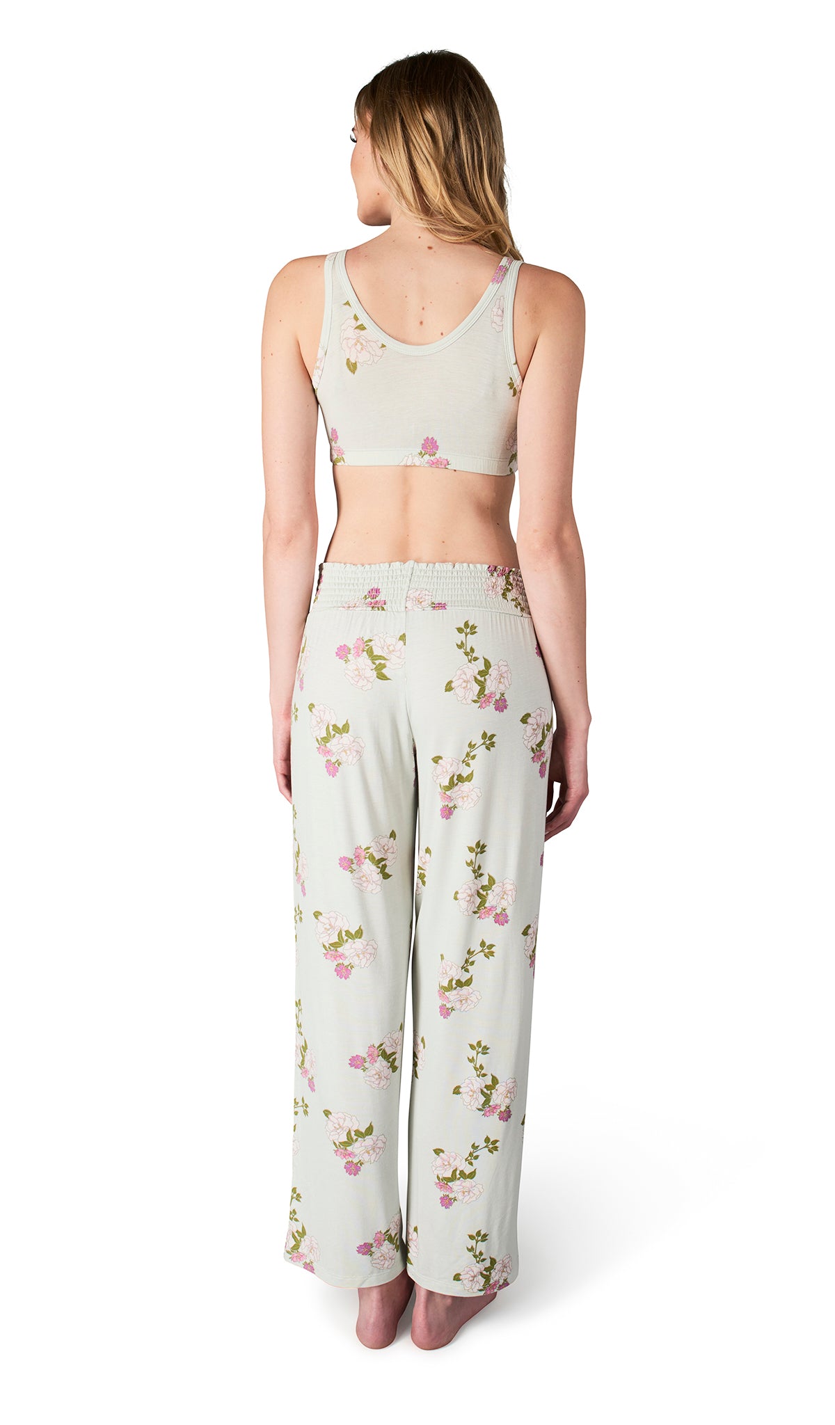 Back shot of woman wearing a floral pajama set on a white background