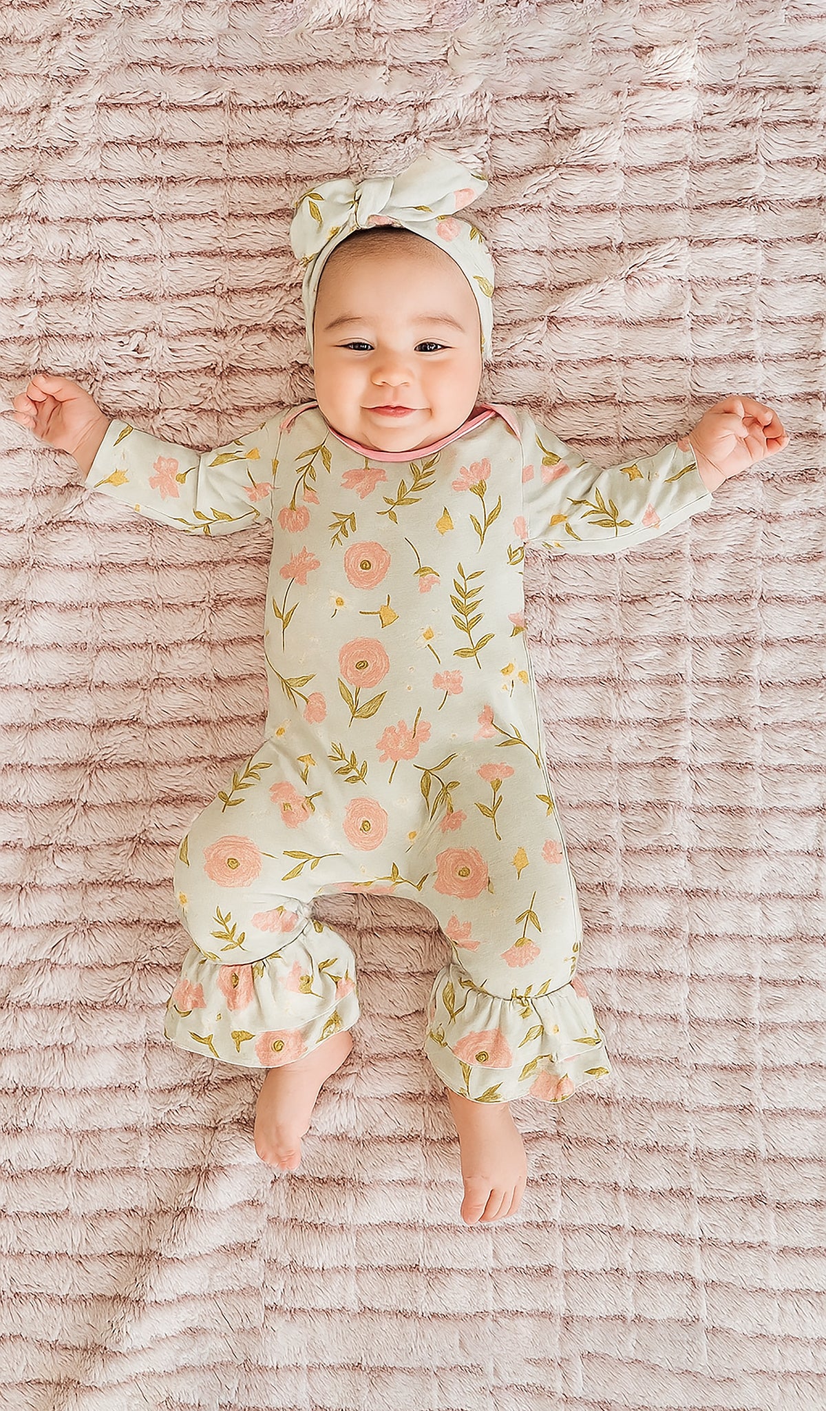 Carnation Ruffle Romper 2-Piece worn by baby girl laying on blanket.