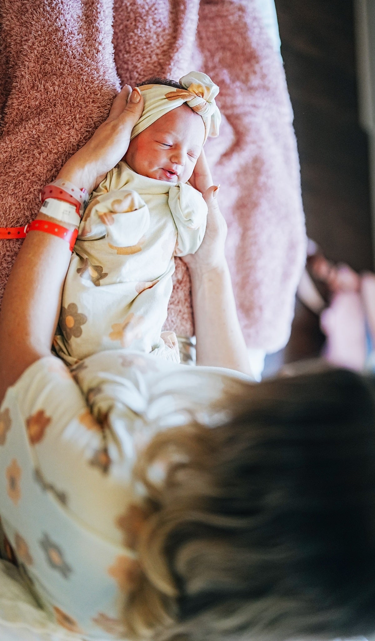 Daisies Knotted Gown 2-Piece Set worn by newborn baby being cradled by her mom.