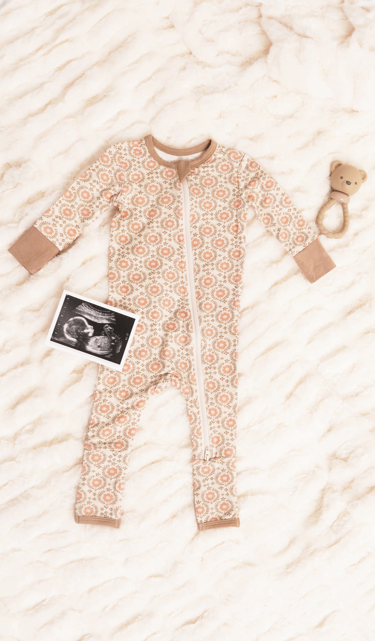 Bohemian Convertible Romper with long sleeves and zip front, one leg folded back to show the grippy sole on the footie.