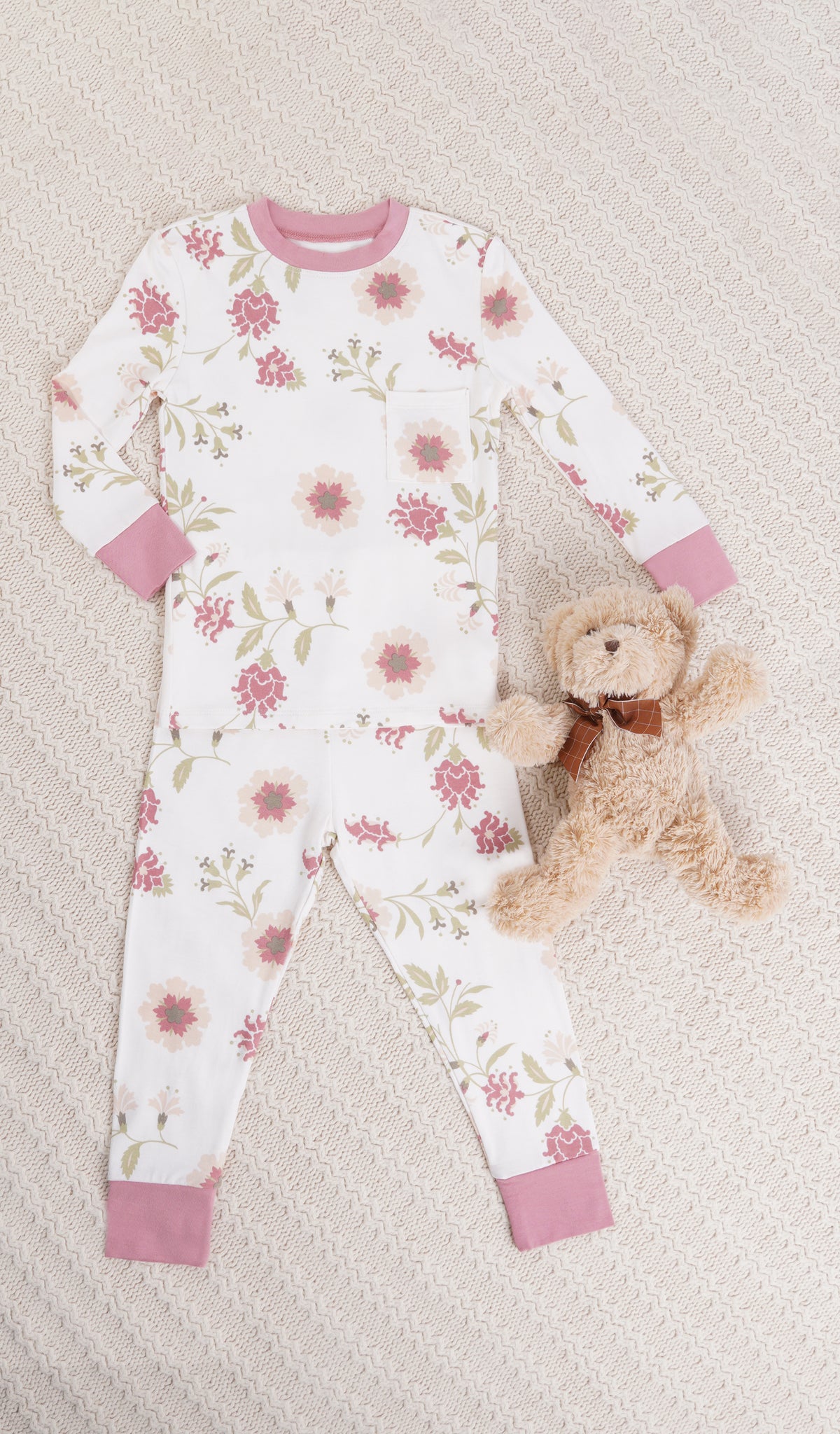 Cottage Floral Emerson Kids 2-Piece Pant PJ. Long sleeve top with cuff trim and long pant with cuff trim and stuffed bear on a knitted beige blanket.