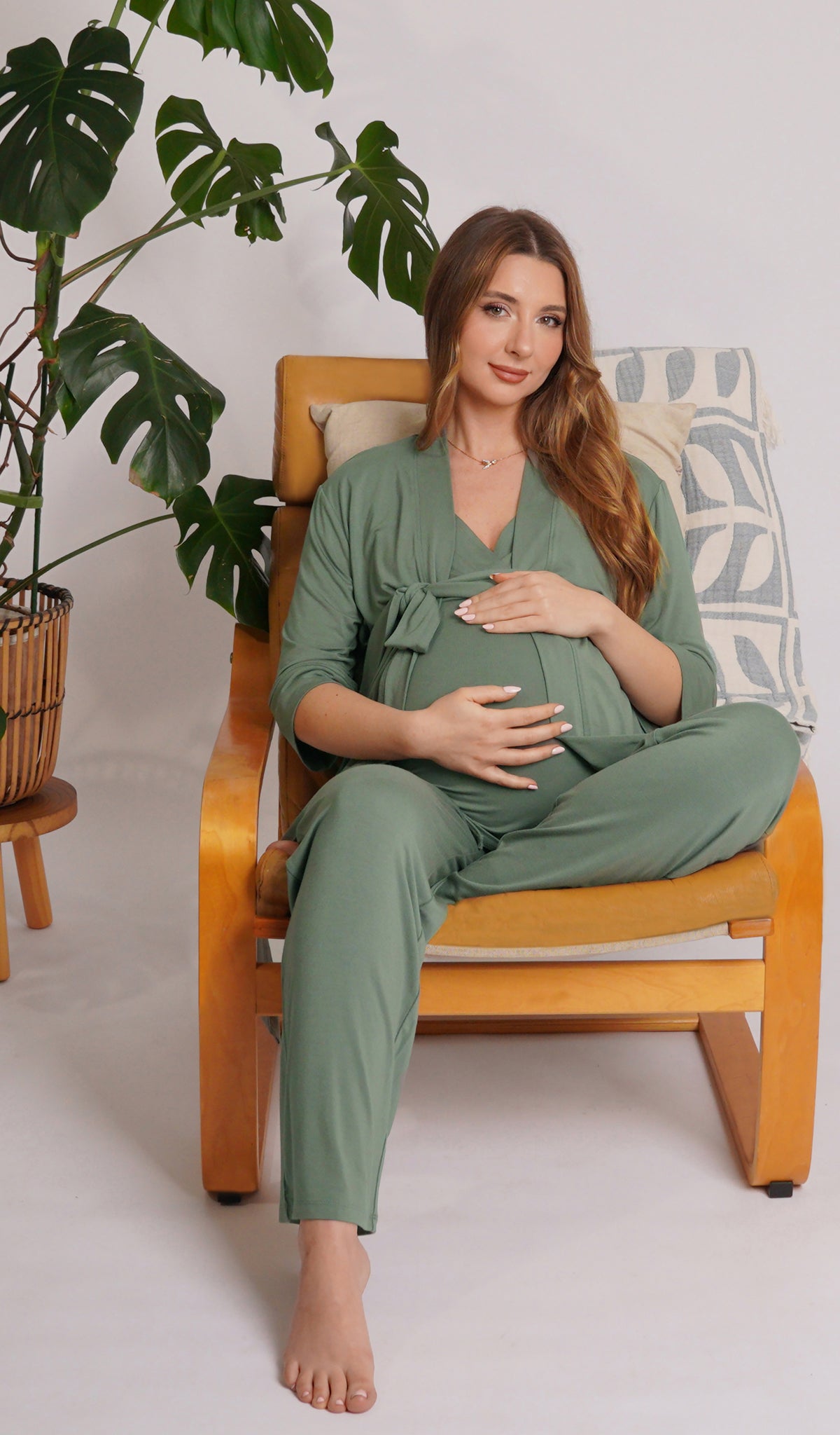 Basil Analise 5-Piece Set worn by pregnant woman sitting with one leg underneath her on chair with hands on belly.