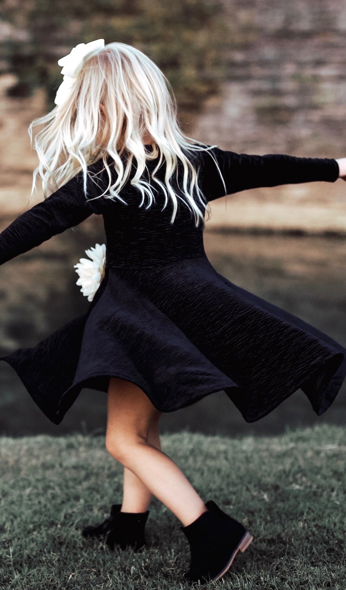 Black Kendyl Kids Twirly Dress worn by little girl twirling.