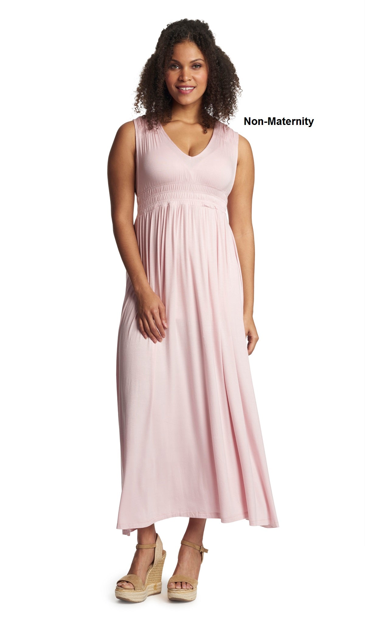 Blush Valeria dress worn as non-maternity style by woman standing with one hand resting on leg.