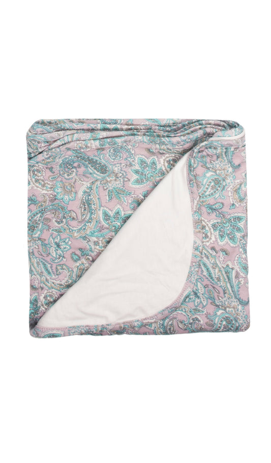 Paisley Swaddle Blanket folded into a square with print showing on one side and reversible contrast solid showing on other side of fold down flap.
